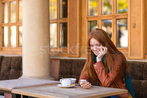 Foto d'archivio: Cute · sorridere · femminile · smartphone · outdoor · cafe