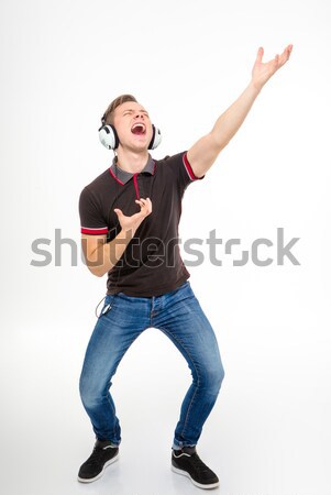 Playful young male listening to music, singing and dancing  Stock photo © deandrobot