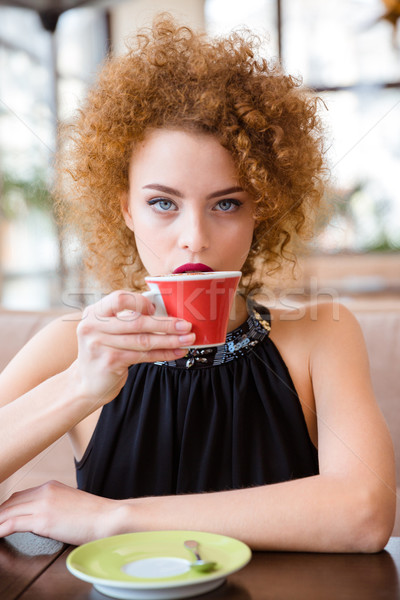 Mulher potável café restaurante cabelos cacheados Foto stock © deandrobot