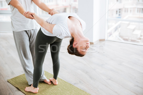 Woman stretching and doing acro yoga with partner in studio Stock photo © deandrobot