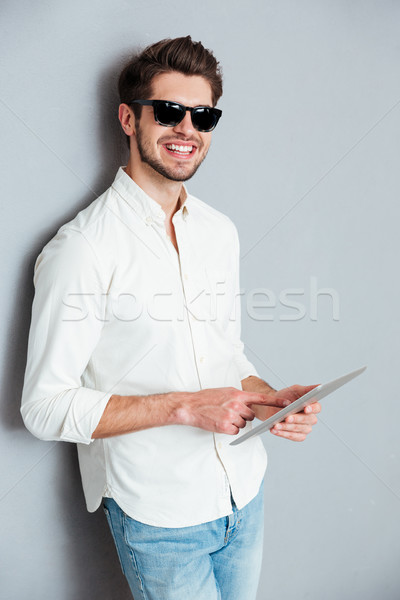 Stock photo: Portrait of a young man holding tablet computer