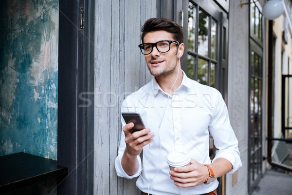 Człowiek smartphone słuchanie muzyki miasta atrakcyjny młody człowiek Zdjęcia stock © deandrobot