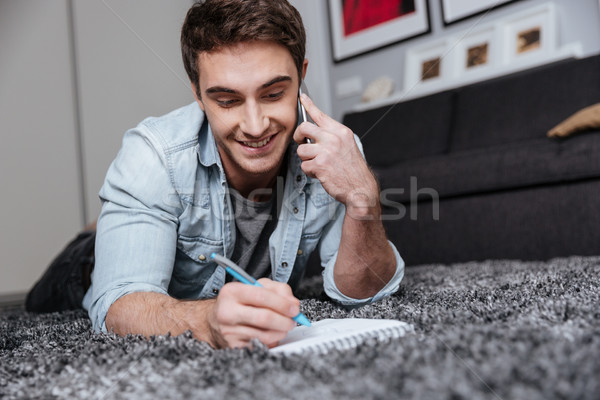 [[stock_photo]]: Homme · tapis · téléphone · portable · souriant · jeune · homme