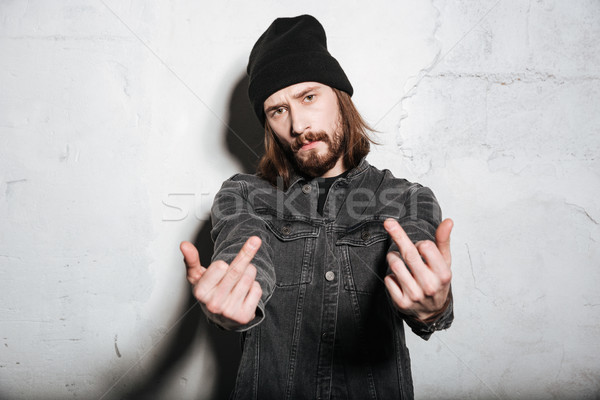 Portrait of a man in hat showing fuck you sign Stock photo © deandrobot