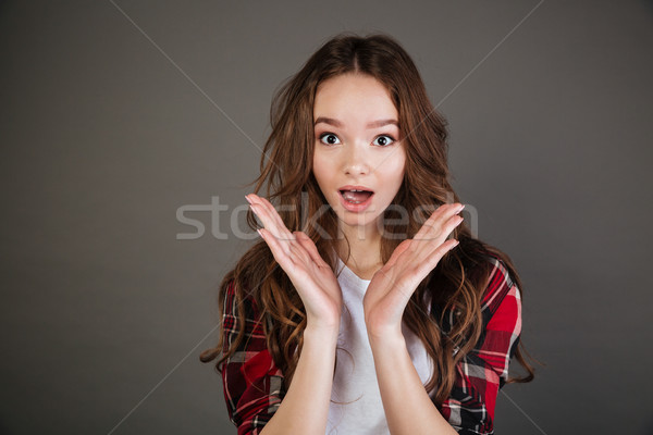 Astonished surprised young woman with opened mouth standing and shouting Stock photo © deandrobot