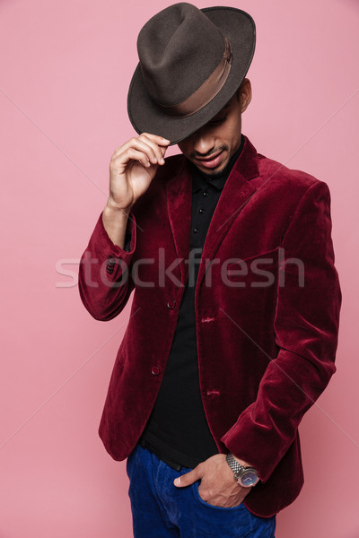 Portrait of a stylish afro american man in jacket and hat posing Stock photo © deandrobot
