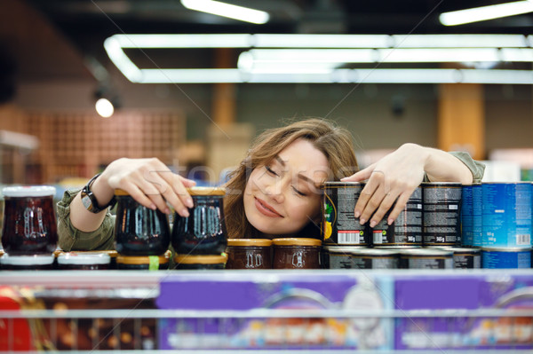 Young woman sleeping on groceries on a supermarket aisle Stock photo © deandrobot