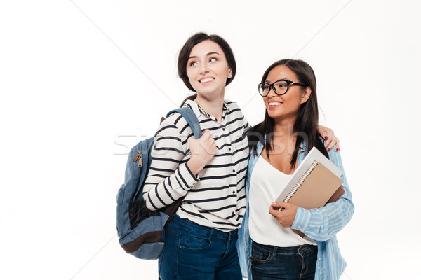 Couple of two happy multiethnic female students with backpack Stock photo © deandrobot