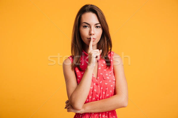 Mystery brunette woman in dress showing silence gesture Stock photo © deandrobot