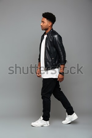 Full length portrait of fashionable african guy in leather jacke Stock photo © deandrobot