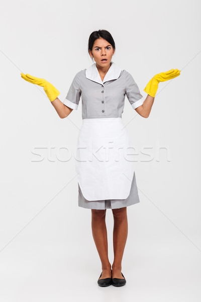 Full length photo of astonished maid in gray uniform and yellow  Stock photo © deandrobot