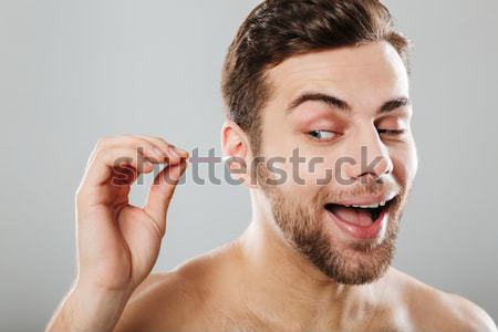 Man in pain removing nose hair with tweezers Stock photo © deandrobot