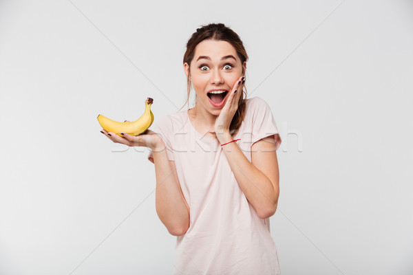Portré meglepődött fiatal lány tart banán néz Stock fotó © deandrobot