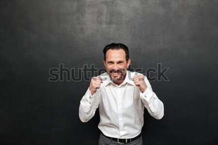 Portrait of brunette man posing on camera using smartphone and c Stock photo © deandrobot