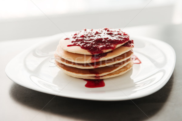 Pancakes with jam at the kitchen in home. Stock photo © deandrobot