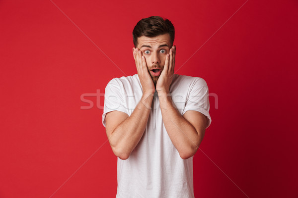Megrémült érzelmes fiatalember kép áll izolált Stock fotó © deandrobot