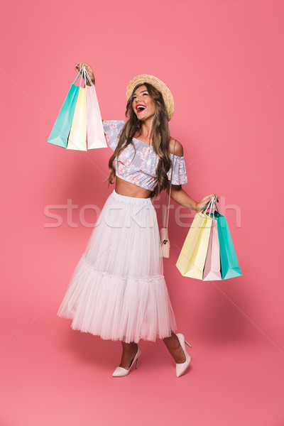 Full length image of cheerful young woman 20s wearing straw hat  Stock photo © deandrobot