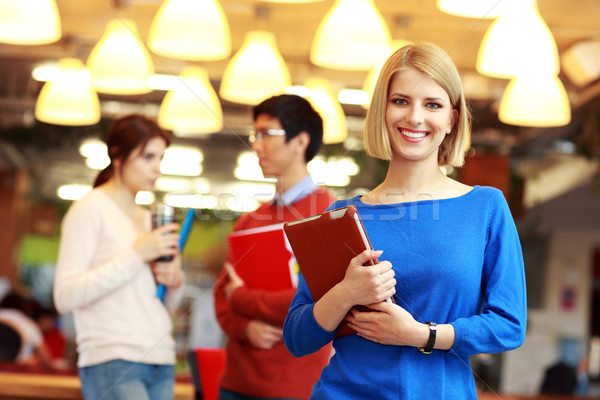 Group of young smiling students at university campus Stock photo © deandrobot