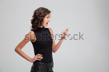 Loco enojado jóvenes femenino gritando teléfono móvil Foto stock © deandrobot