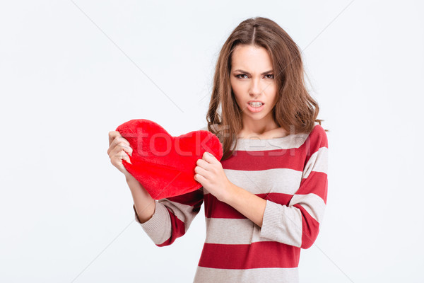 Angry woman holding red heart Stock photo © deandrobot