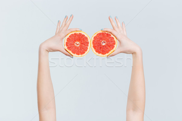 Female hands holding grapefruits Stock photo © deandrobot