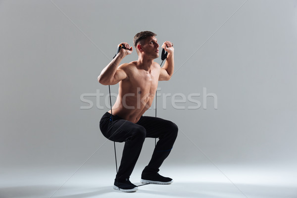 Fitness man squatting with expander Stock photo © deandrobot