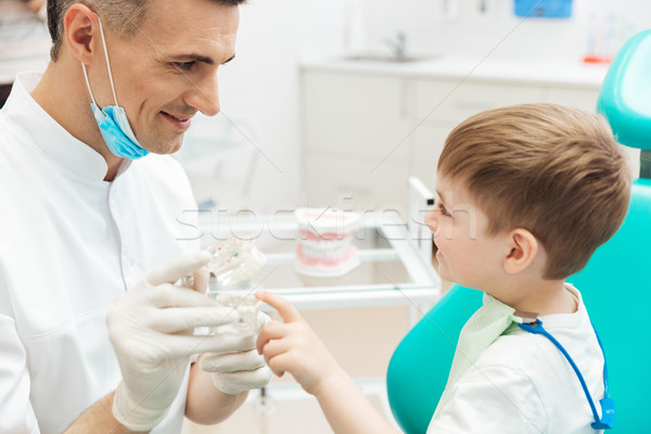 Boy on cosultation of pediatrician dentist using dental jaw model Stock photo © deandrobot