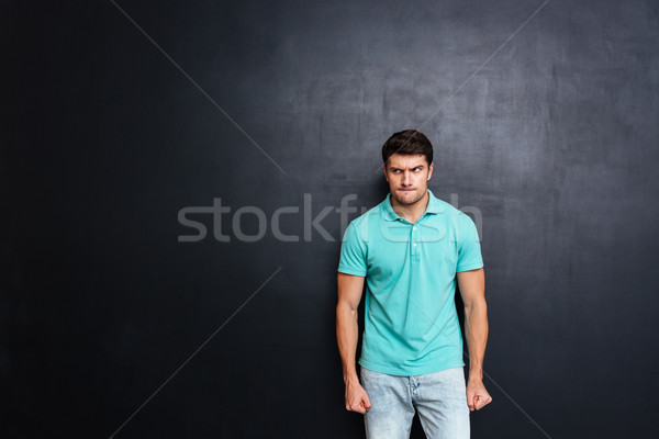 Mérges ingerült fiatalember másfelé néz tábla háttér Stock fotó © deandrobot