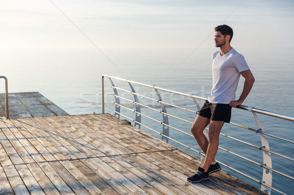 Sportsman standing on pier in the morning Stock photo © deandrobot