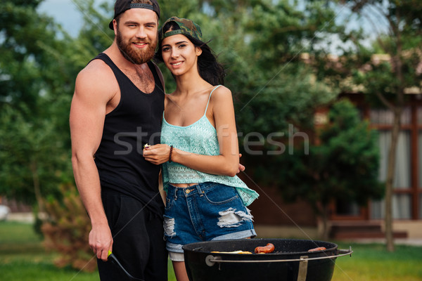 Beautiful young couple standing near barbeque grill outdoors Stock photo © deandrobot