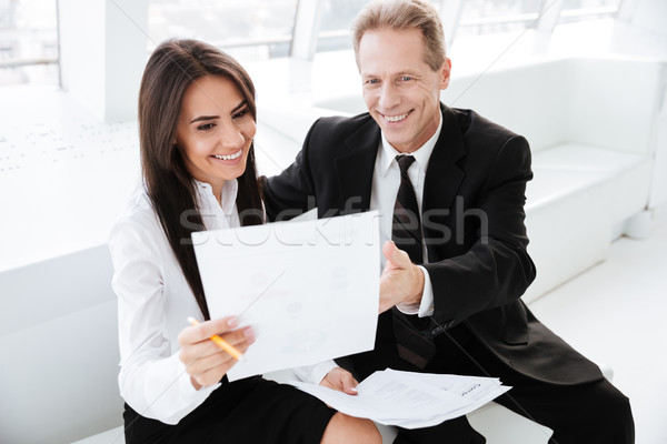 Szczęśliwy ludzi biznesu dokumentów posiedzenia sofa patrząc Zdjęcia stock © deandrobot