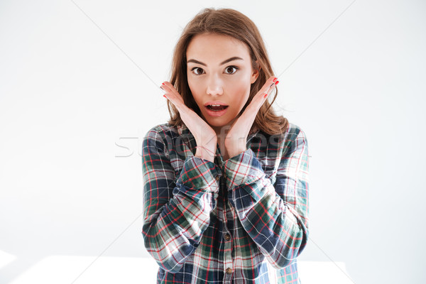 Surprised wondered young woman in plaid shirt with opened mouth Stock photo © deandrobot