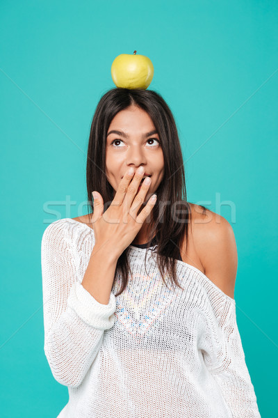 Woman with apple on head covering mouth by hand Stock photo © deandrobot