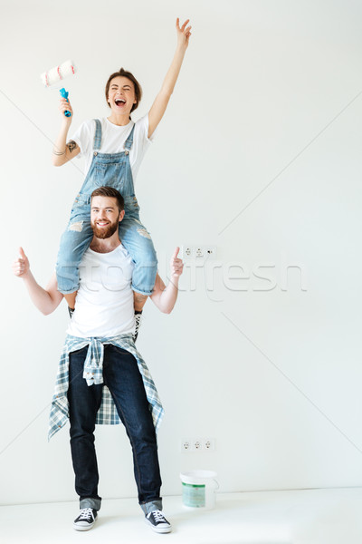 Happy cheerful couple renovating their house walls together Stock photo © deandrobot