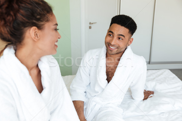 Smiling young african loving couple sitting on bed Stock photo © deandrobot