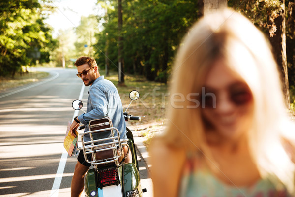 Happy loving couple near scooter outdoors. Looking aside Stock photo © deandrobot