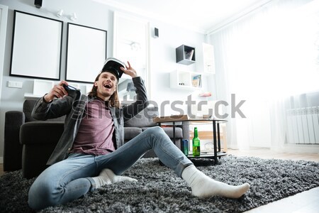 Happy man sitting at home indoors play games with joystick Stock photo © deandrobot