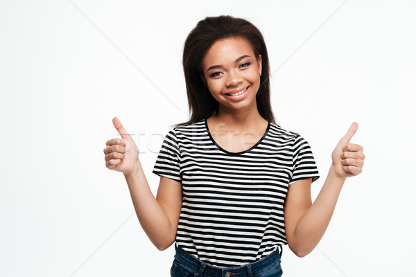 Cheerful young african lady showing thumbs up Stock photo © deandrobot