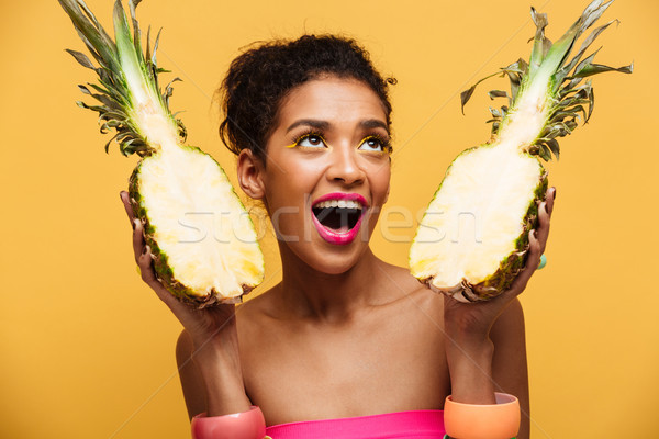 Hungry mulatto woman with colorful makeup looking upward and hol Stock photo © deandrobot