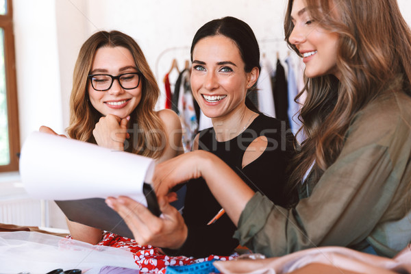 Three lovely young women clothes designers Stock photo © deandrobot