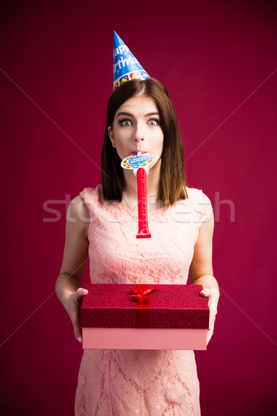 Stock photo: Woman blowing in whistle and holding gift box