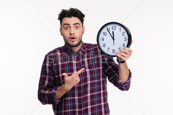 Young casual man holding wall clock Stock photo © deandrobot