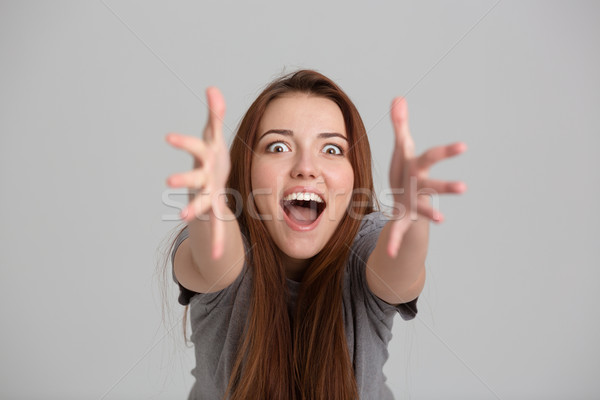 Boldog izgatott fiatal nő kiált kezek kamerába Stock fotó © deandrobot