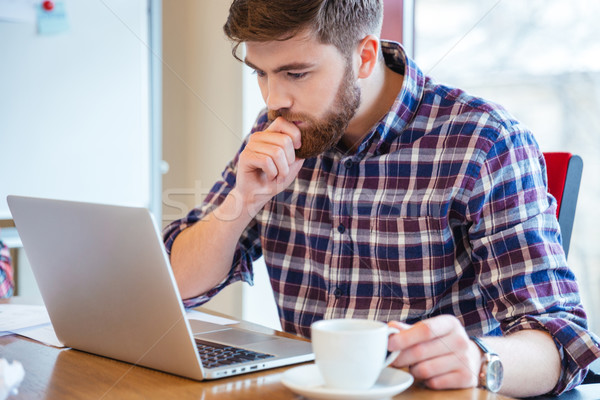 Komoly fókuszált férfi ül asztal laptopot használ Stock fotó © deandrobot