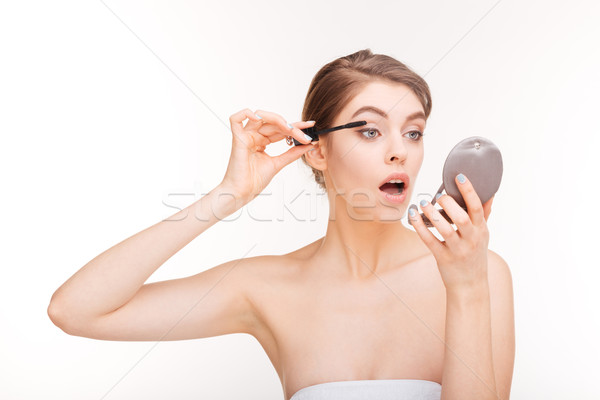 Woman applying mascara on her eyelashes Stock photo © deandrobot