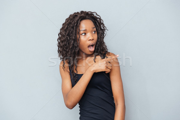 Meglepett afro amerikai nő mutat ujj Stock fotó © deandrobot
