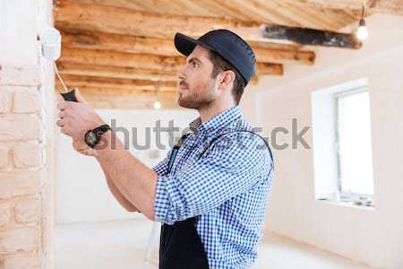 Close-up portrait of a decorator using roller during work Stock photo © deandrobot