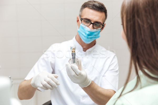 Dentist explaining teeth model to female patient Stock photo © deandrobot