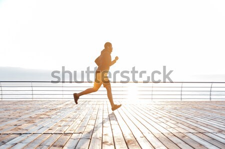 Stock photo: Attractive man running on wooden terrace