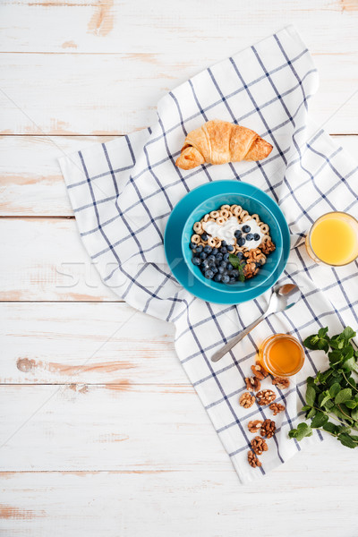 Oat cereals with berries and cream, cup of orange juice Stock photo © deandrobot